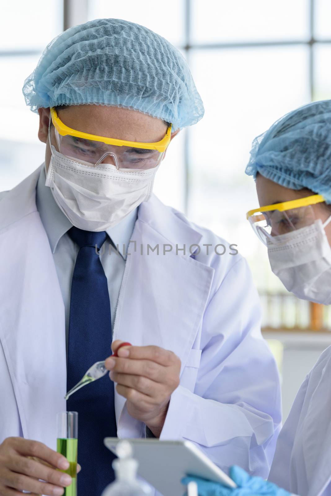 Asian senior scientist have teaching young student scientist in a laboratory.