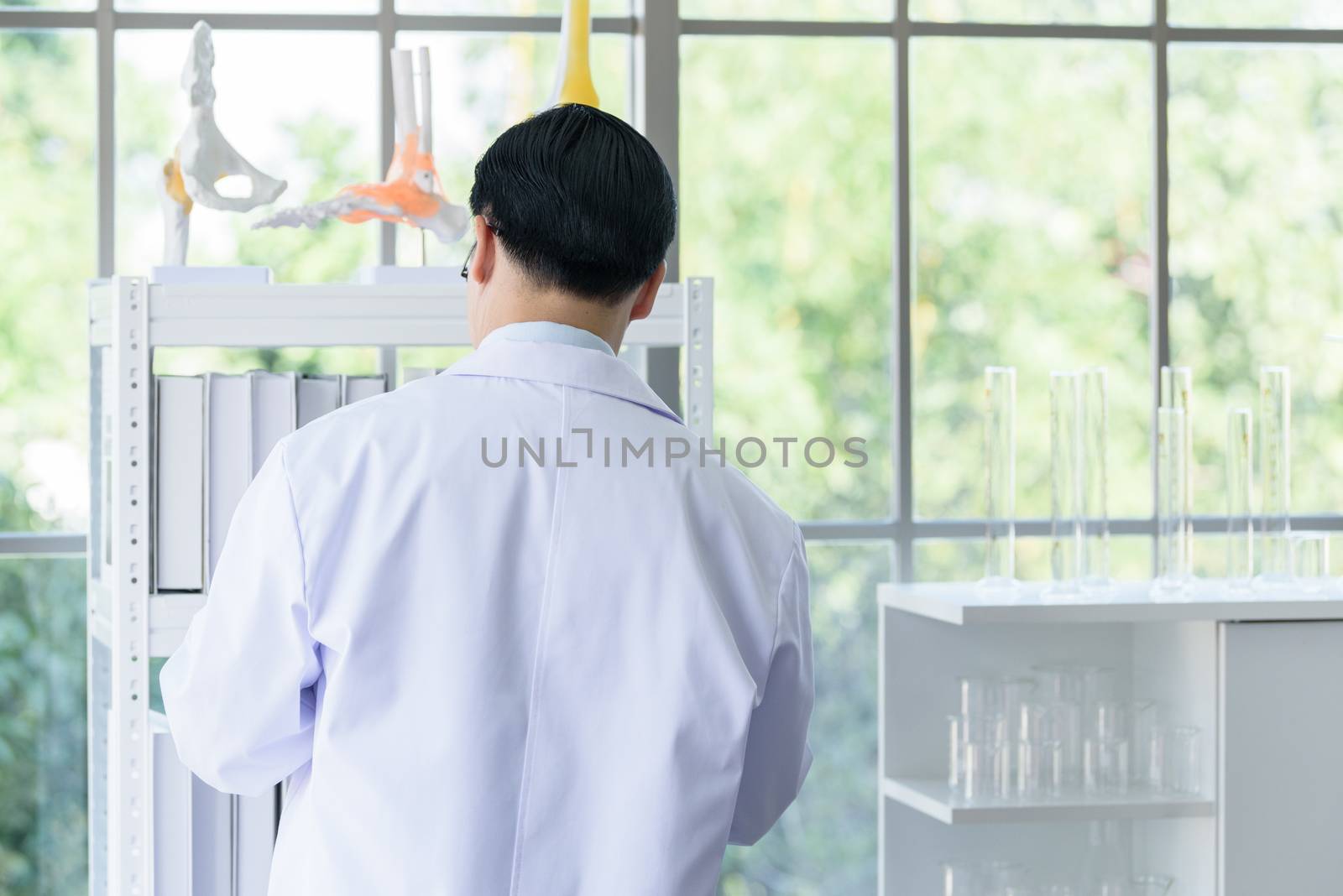 Asian senior scientist researching and learning in a laboratory. by animagesdesign