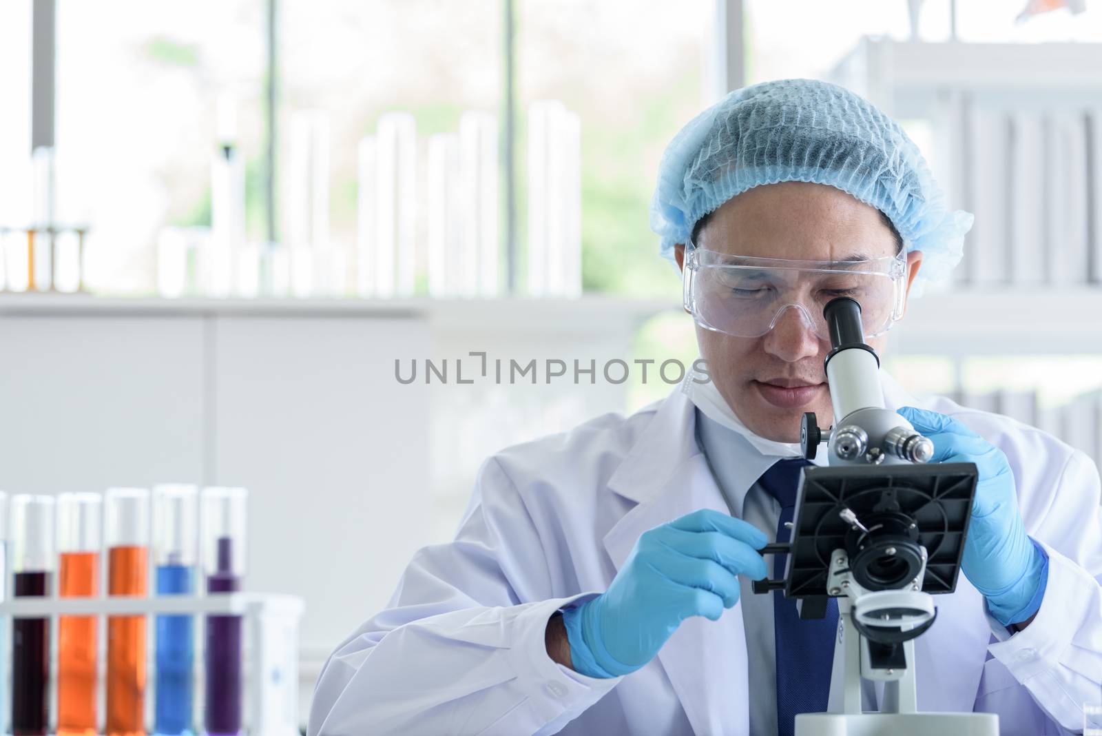 Asian man scientist researching  and learning in a laboratory. by animagesdesign