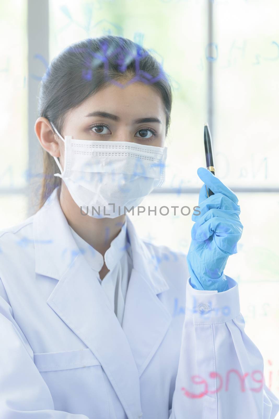 Asian young girl student scientist has writing and researching in laboratory.