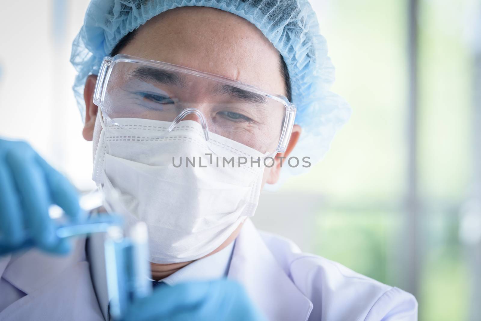 Asian man scientist researching  and learning in a laboratory. by animagesdesign