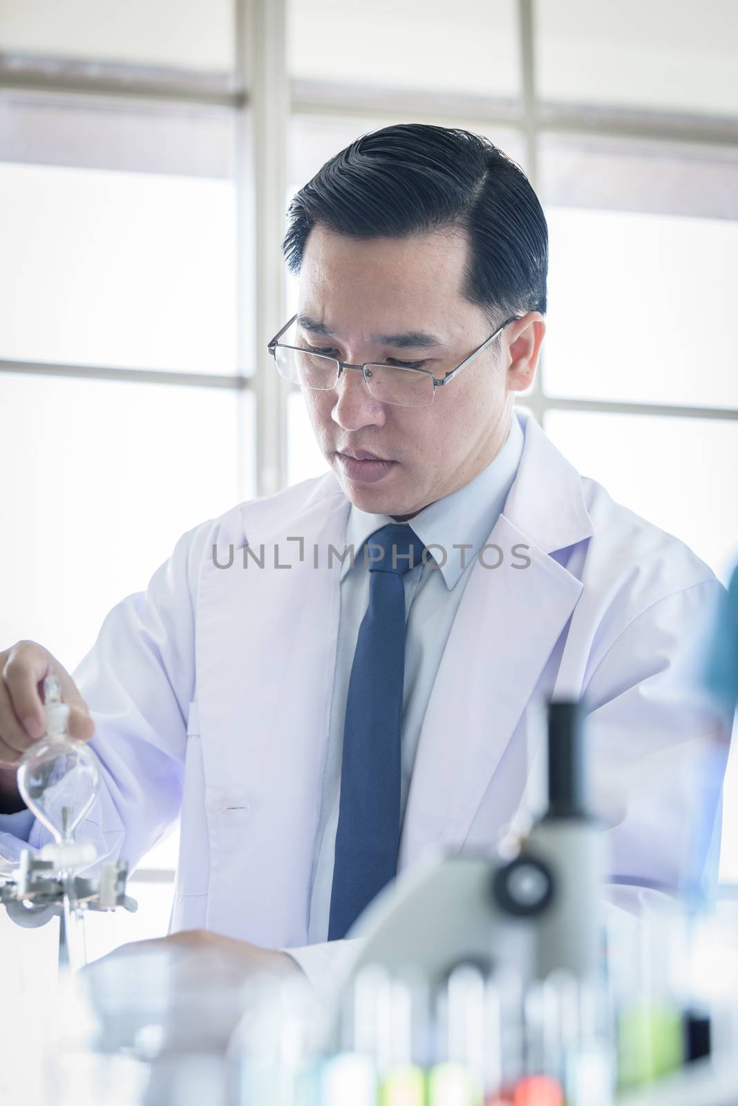 Asian senior scientist researching and learning in a laboratory. by animagesdesign
