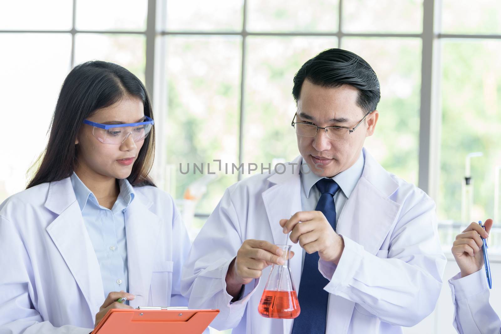 Asian senior laboratory scientist man working at lab with asian young student scientist backgroud.