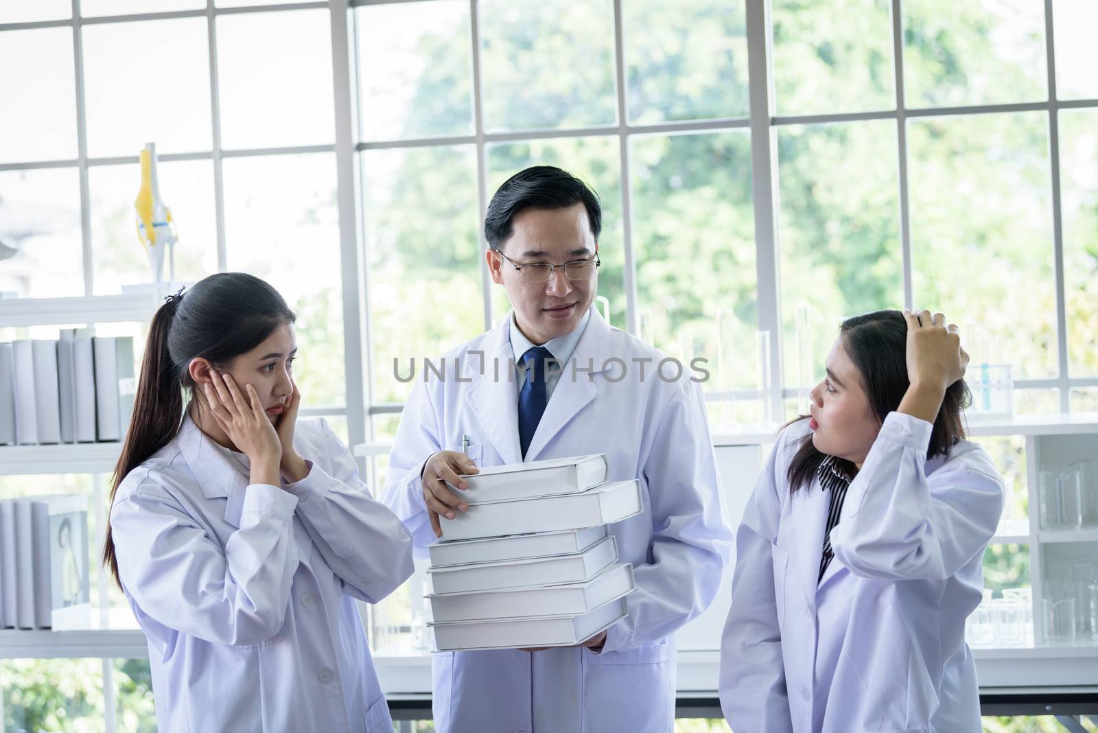 Senior asian scientist has assigning new job to students in laboratory.