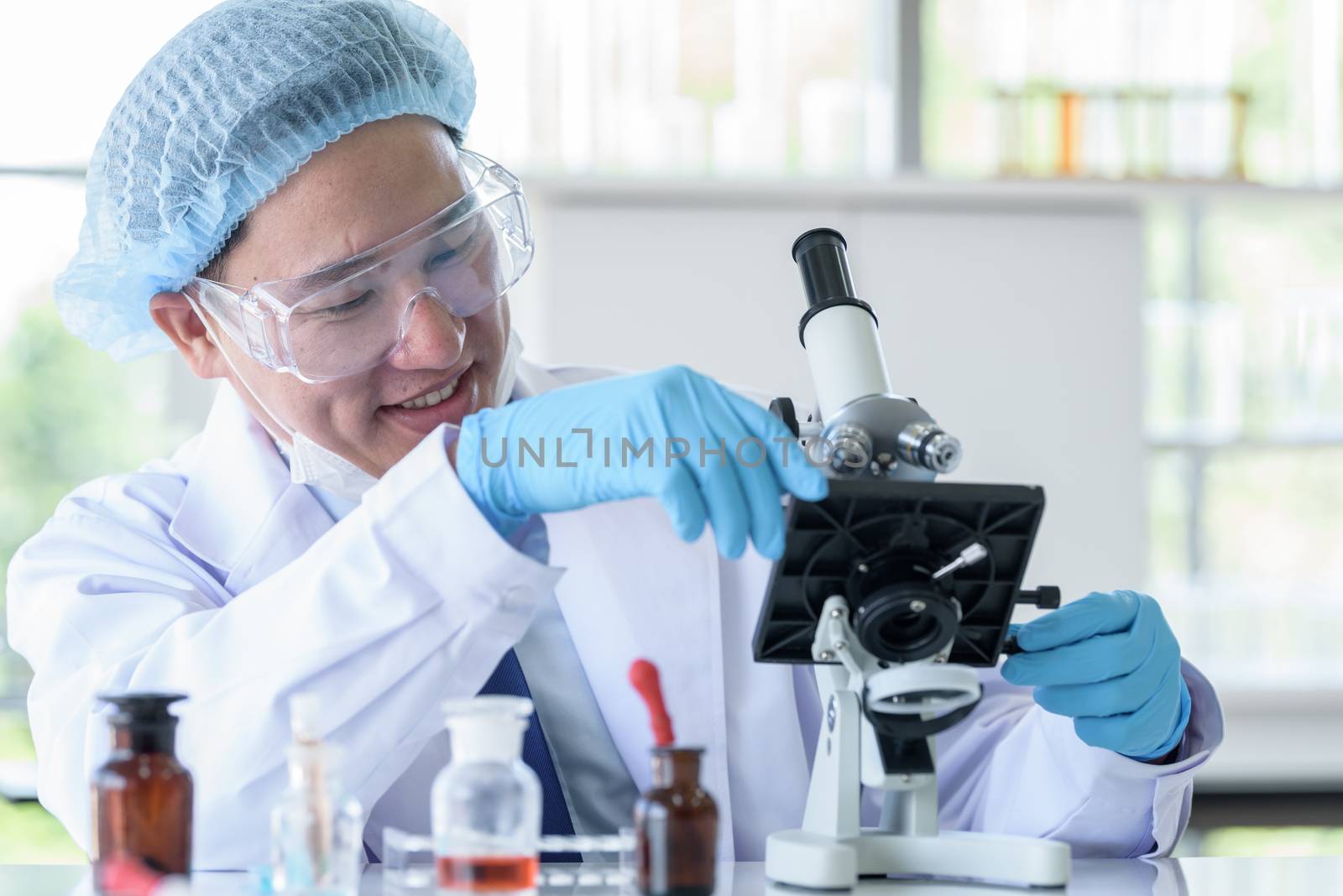 Asian man scientist researching  and learning in a laboratory.