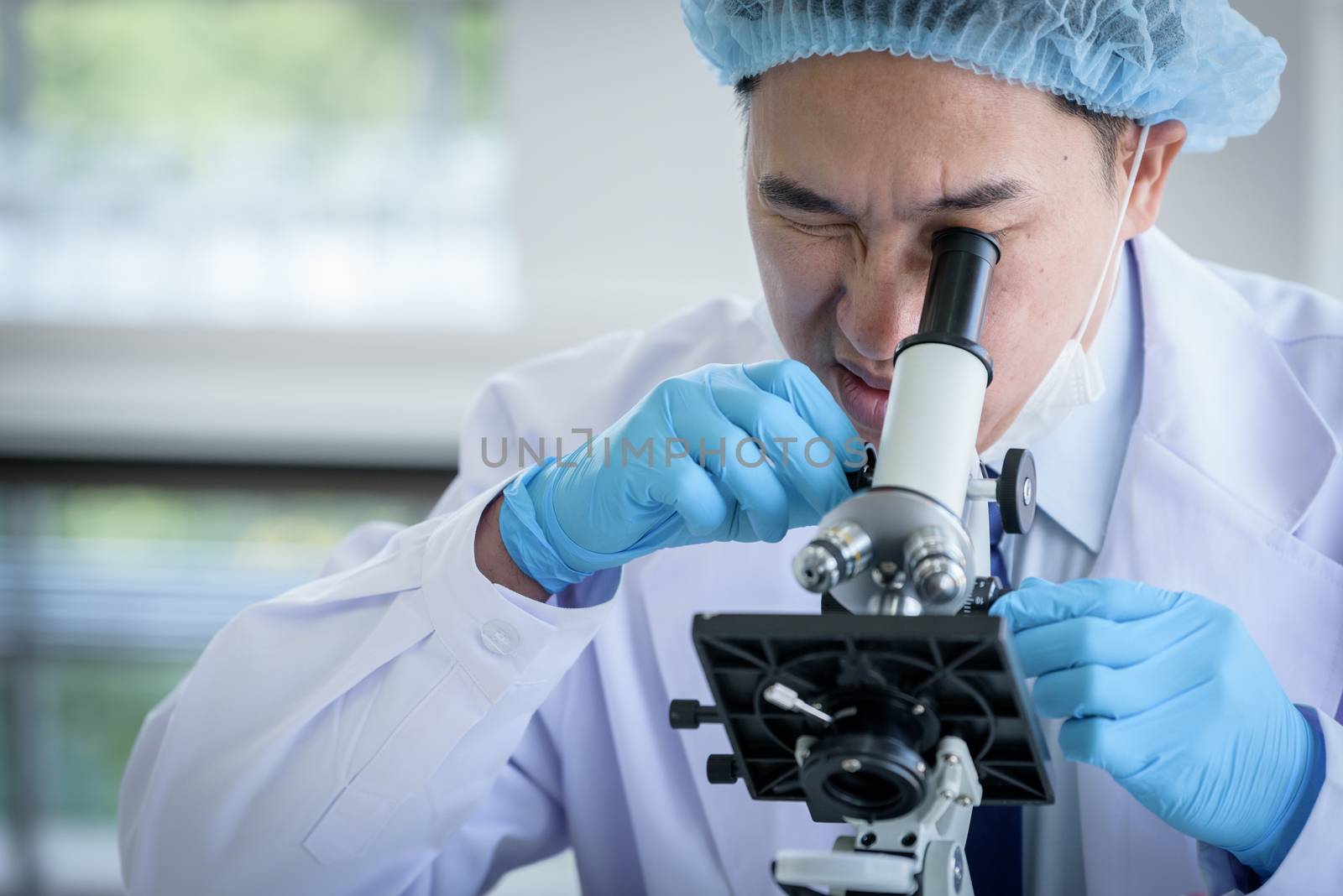 Asian man scientist researching  and learning in a laboratory. by animagesdesign