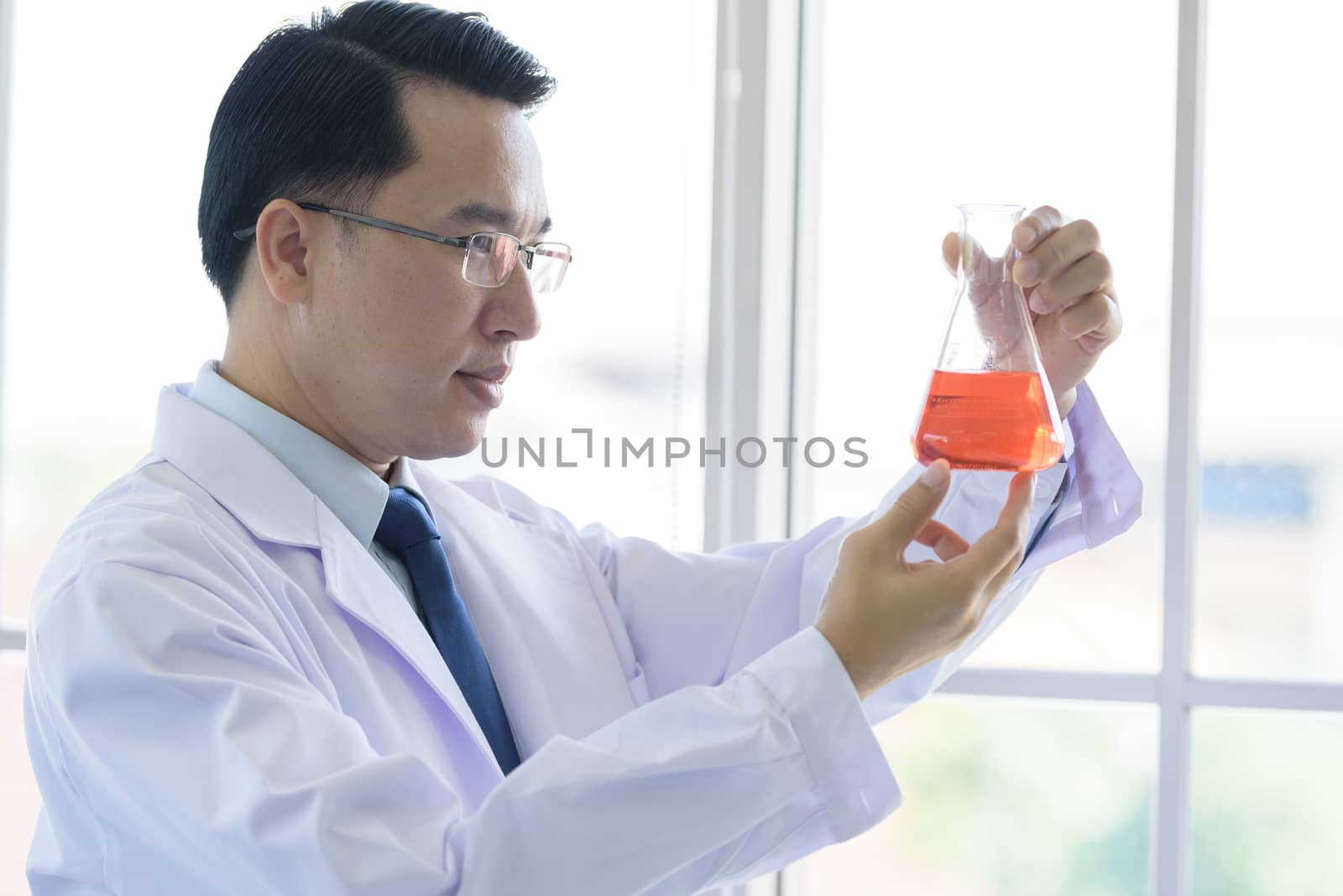 Asian Laboratory scientist man working at lab with test red tubes.