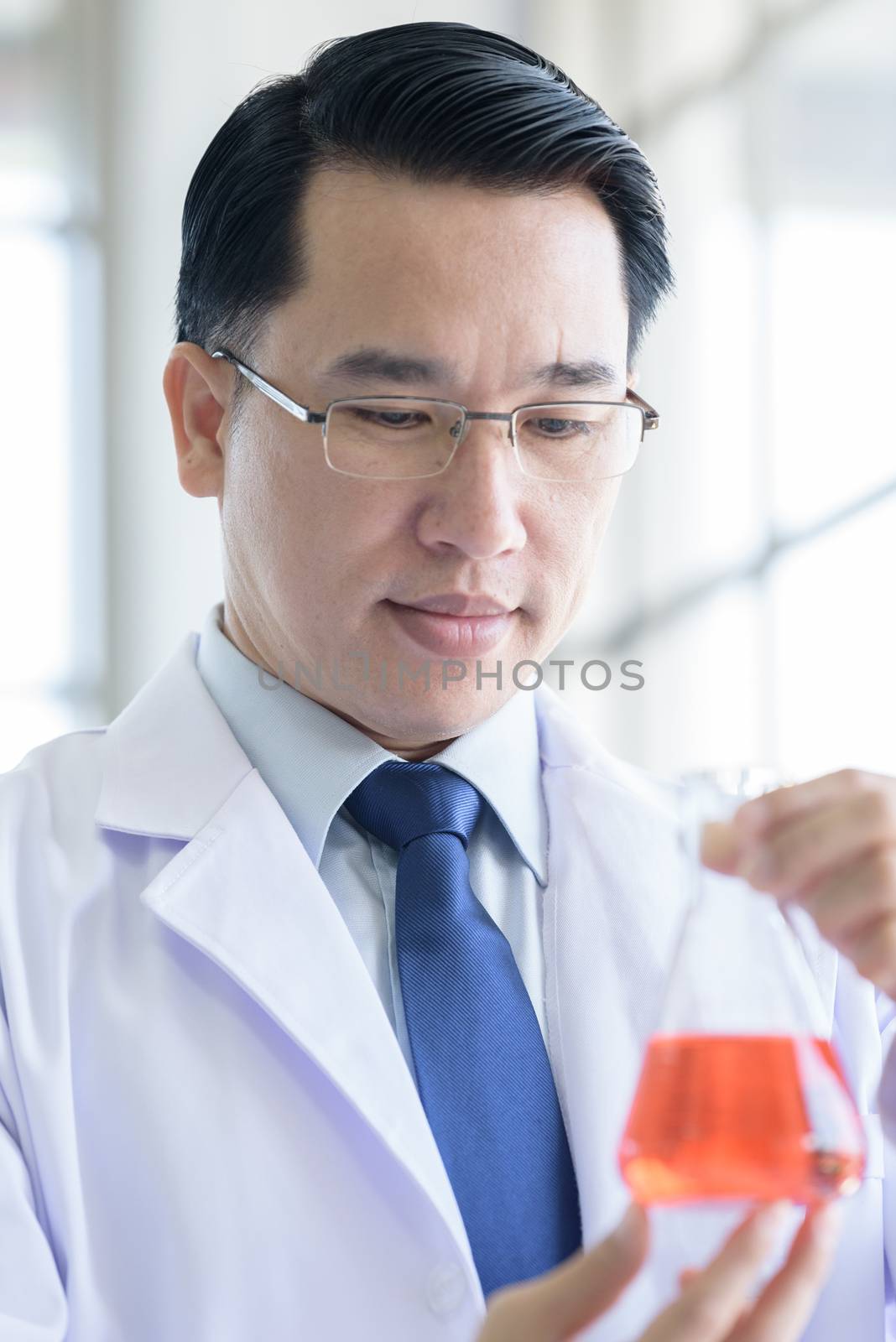 Asian Laboratory scientist man working at lab with test red tubes.