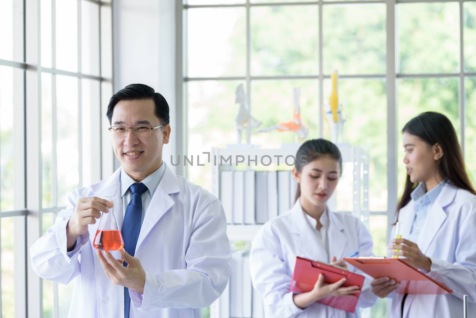 Asian senior laboratory scientist man working at lab with asian young student scientist backgroud.