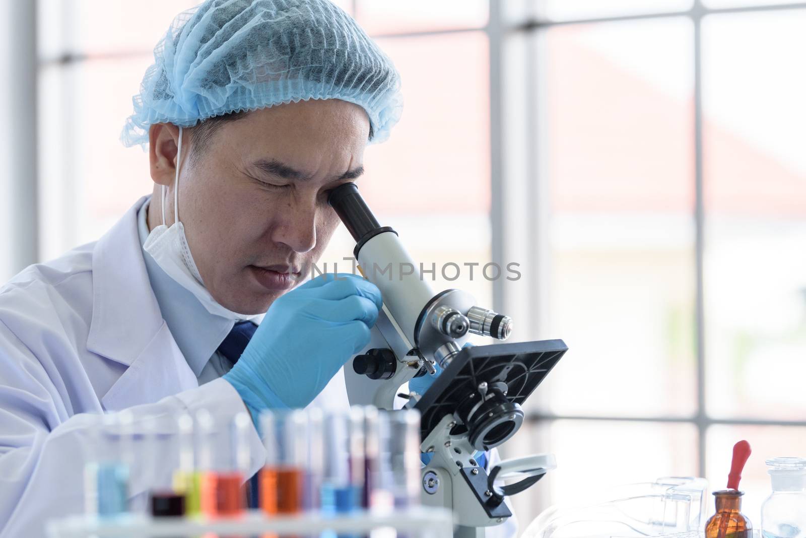 Asian man scientist researching  and learning in a laboratory.