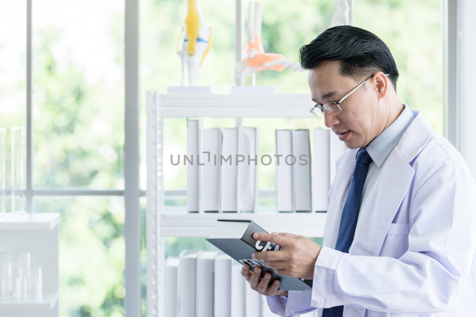 Asian senior scientist researching and learning in a laboratory. by animagesdesign