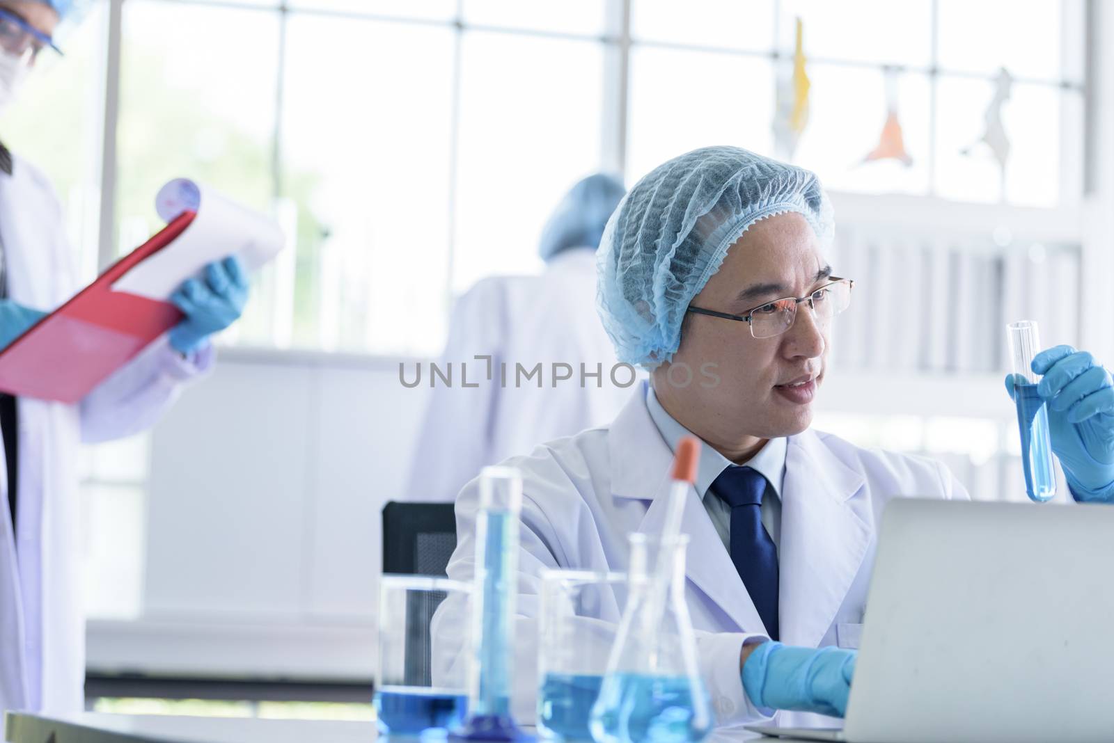 Asian senior scientist male researching and learning in a labora by animagesdesign