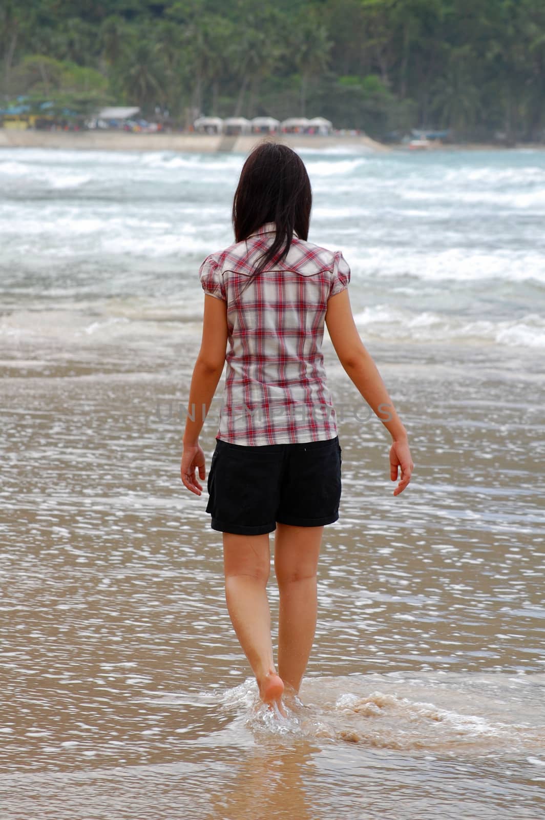 Woman walking on the beach water by imwaltersy