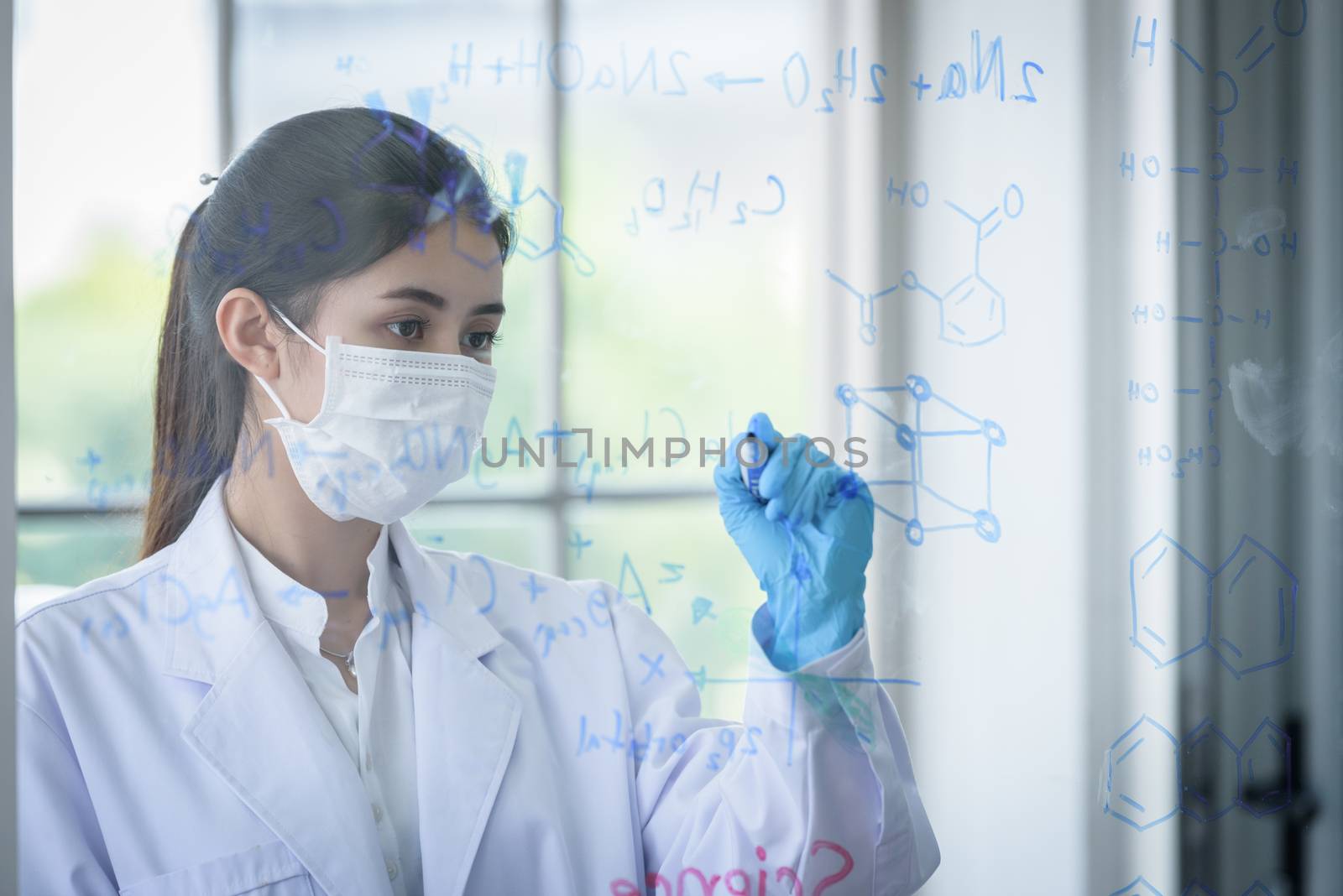 Asian young girl student scientist has writing and researching in laboratory.