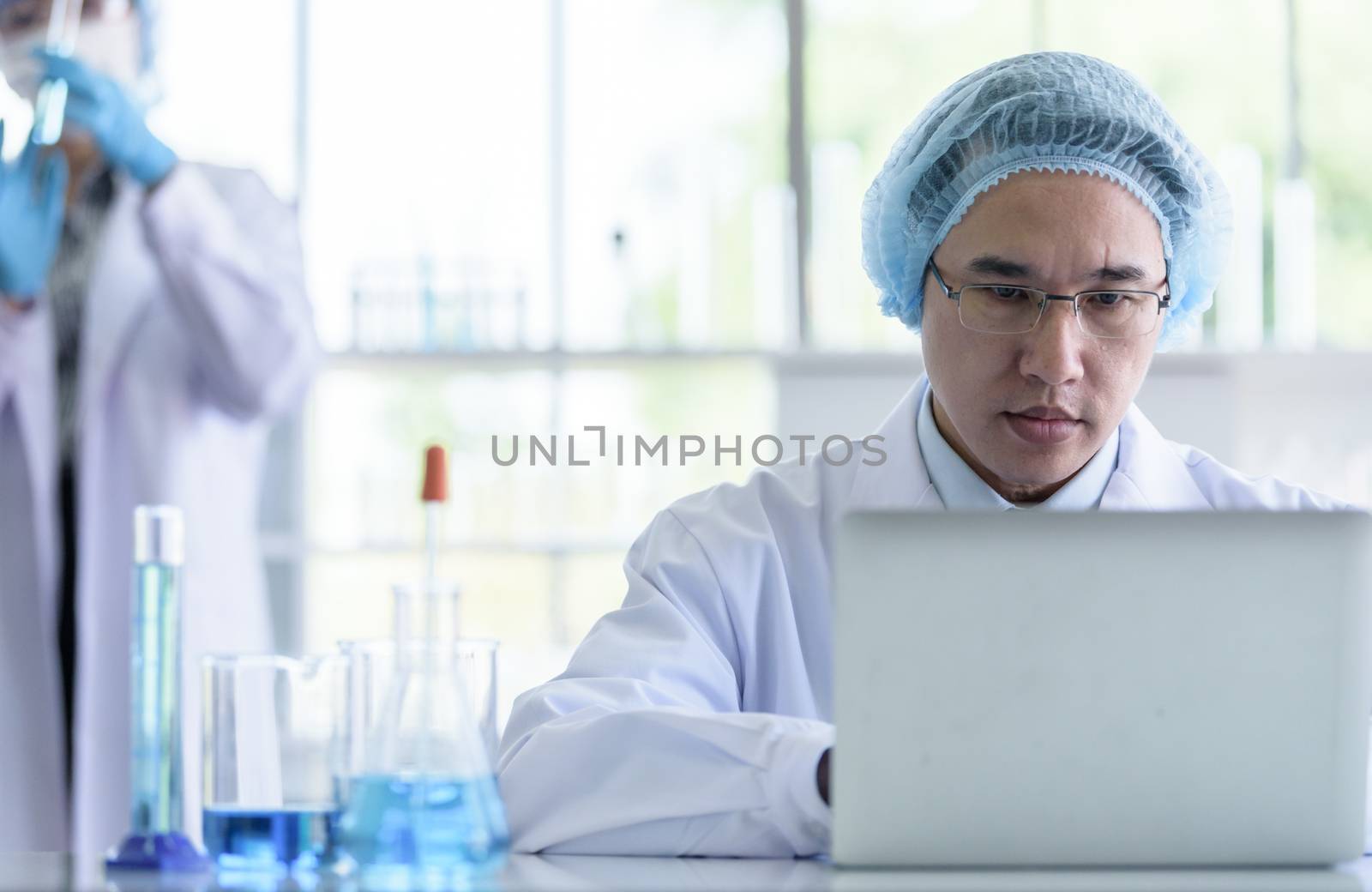Asian senior scientist male researching and learning in a labora by animagesdesign