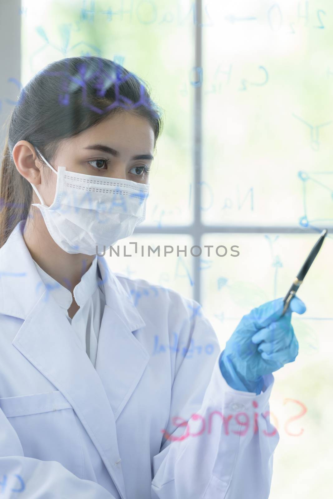 Asian young girl student scientist has writing and researching in laboratory.