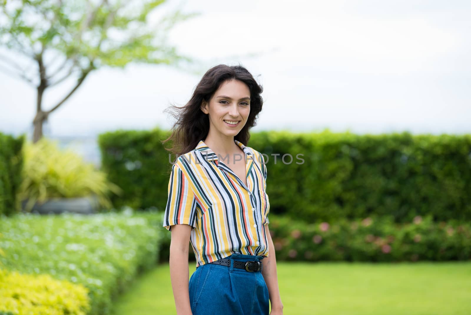 Portrait of a beautiful woman smiling in the garden. by animagesdesign