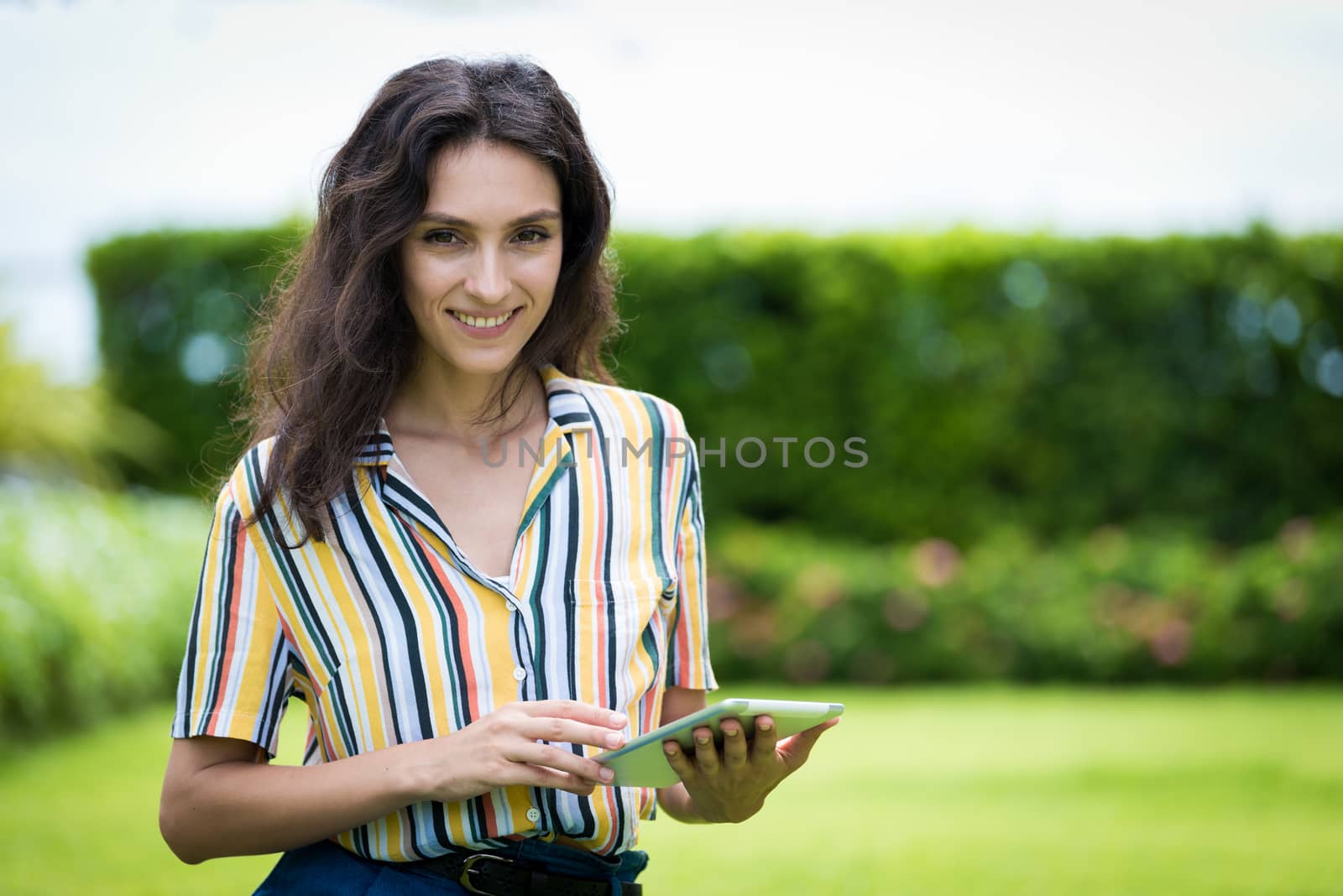 Portrait of a beautiful woman has playing tablet with smiling in by animagesdesign