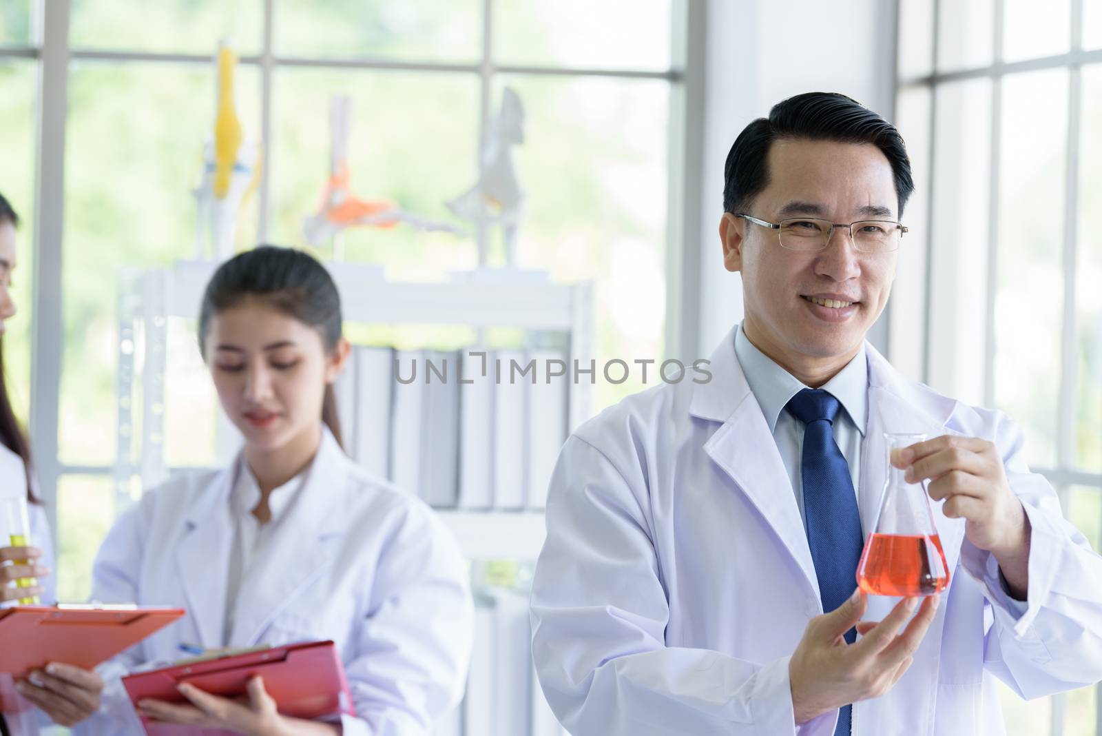 Asian senior laboratory scientist man working at lab with asian young student scientist backgroud.