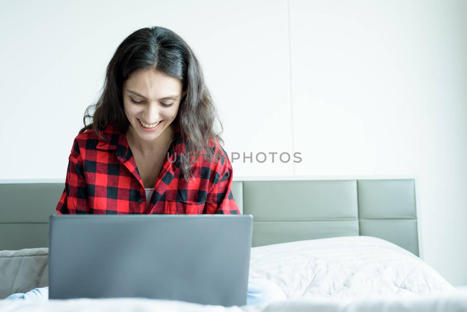 Beautiful woman working on a laptop with smiling and sitting on  by animagesdesign