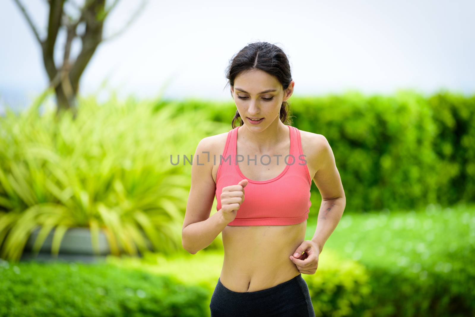 Beautiful woman runner has to warm up in the garden. by animagesdesign