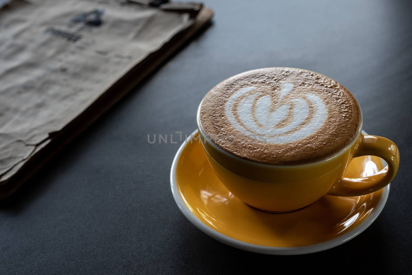 A cup of coffee with beautiful latte art and drink menu on black table background.