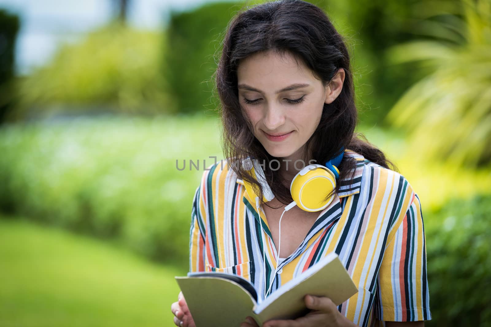 Portrait of a beautiful woman has reading a book with smiling and relax in the garden.