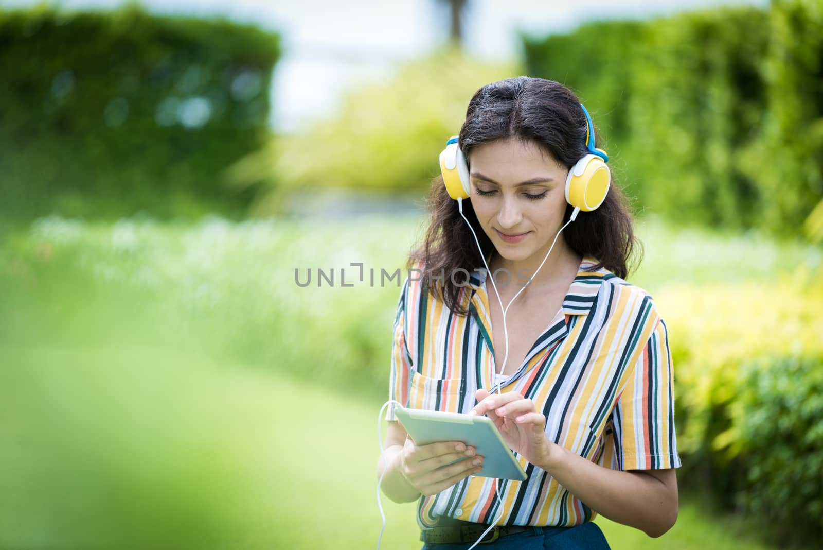 Portrait of a beautiful woman has listening to music with smiling and relax in the garden.