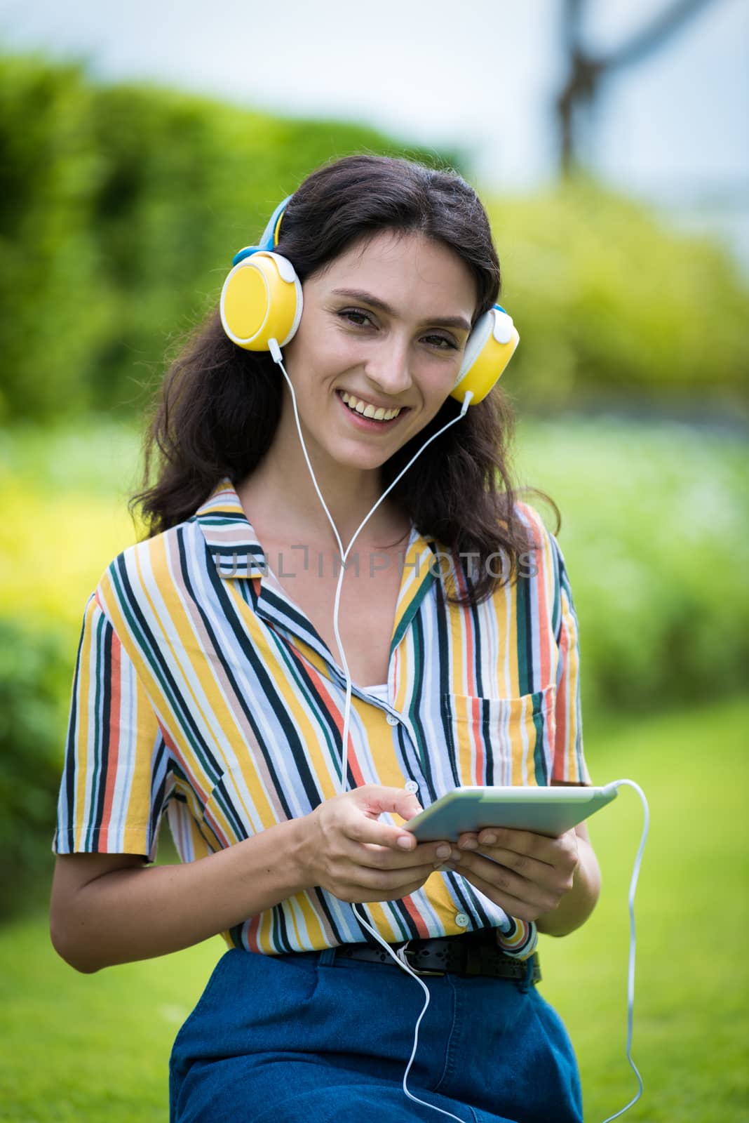 Portrait of a beautiful woman has listening to music with smiling and relax in the garden.