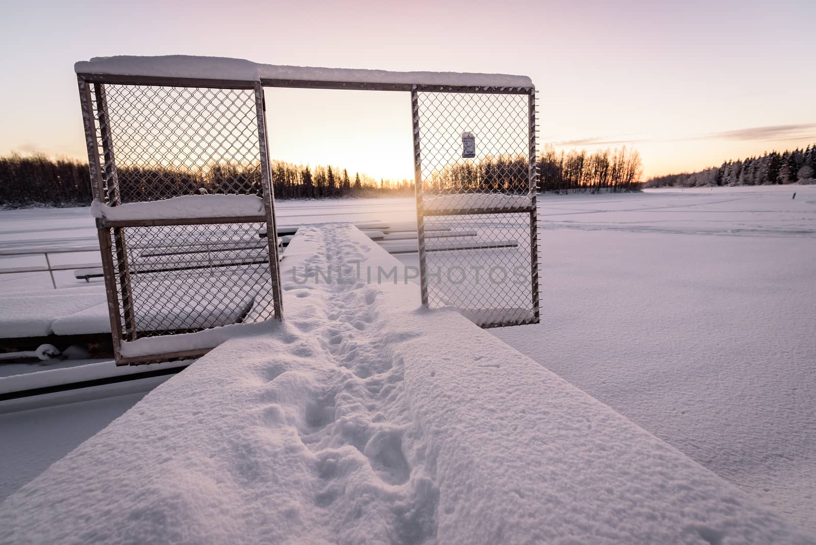 The ice lake and forest has covered with heavy snow and nice blue sky in winter season at Holiday Village Kuukiuru, Finland.