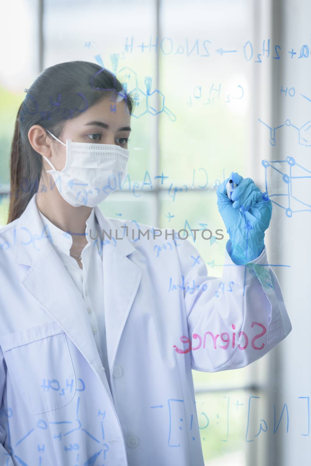 Asian young girl student scientist has writing and researching in laboratory.