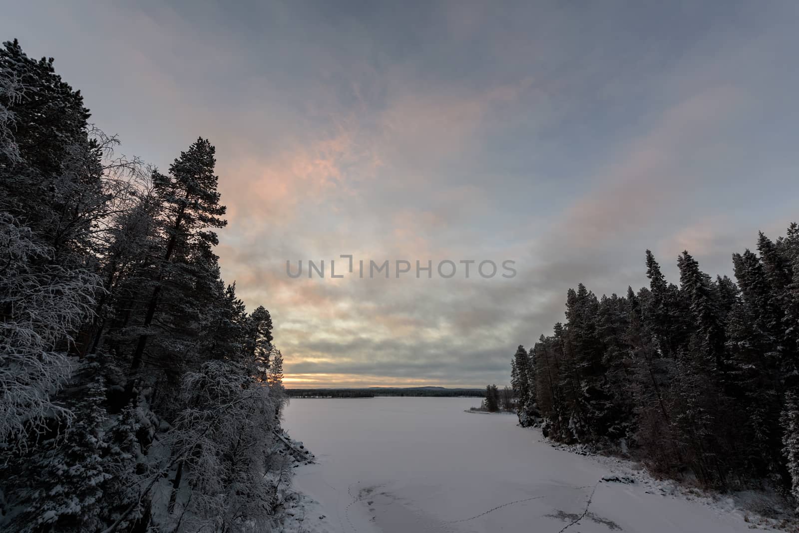 The ice lake has covered with heavy snow and sky in winter season at Oulanka National Park, Finland.