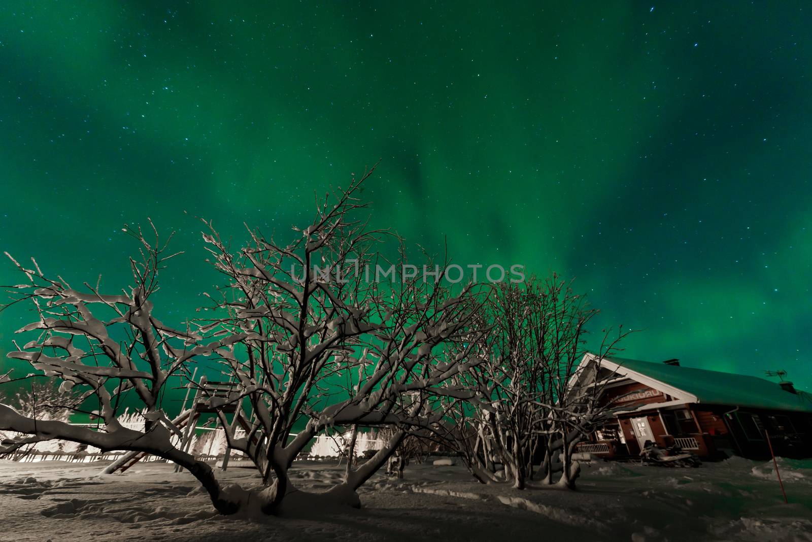 The northern lights Aurora Borealis at Kuukiuru village lake in Lapland, Finland.