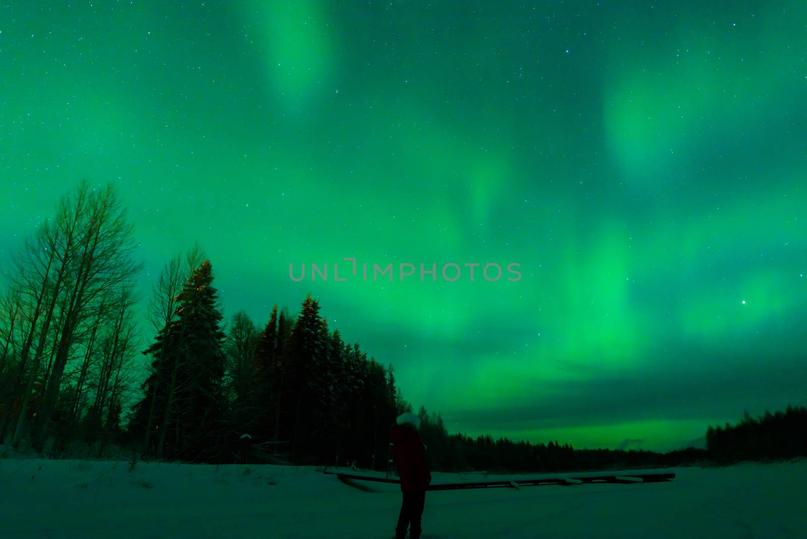 People has looking the northern lights Aurora Borealis at Kuukiuru village lake in Lapland, Finland.