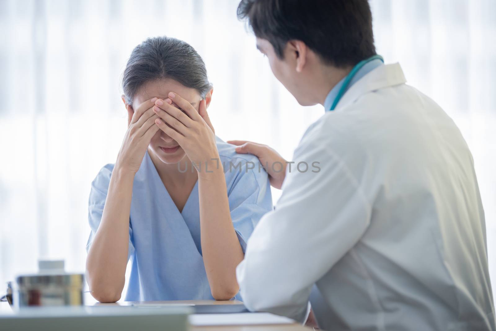 A doctor takes care of a sick patient woman with sadness and unhappiness at the hospital or medical clinic.