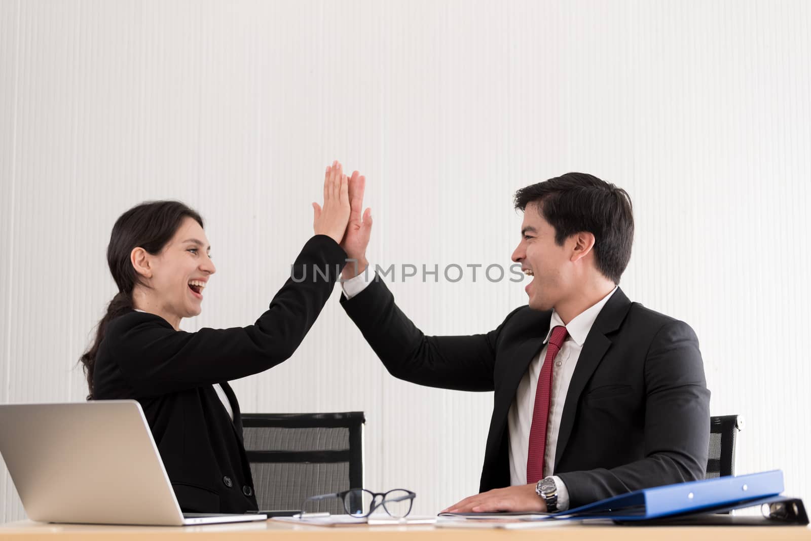 A manager and secretary working together with success and happiness in the office.