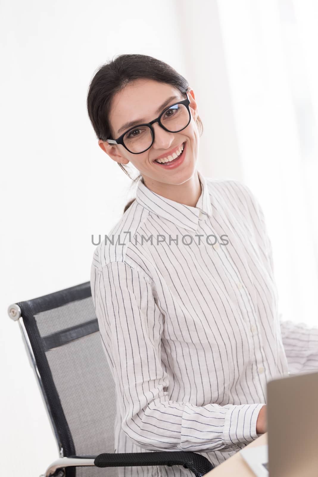 A businesswoman wearing glasses working with smiling and happiness at the office.