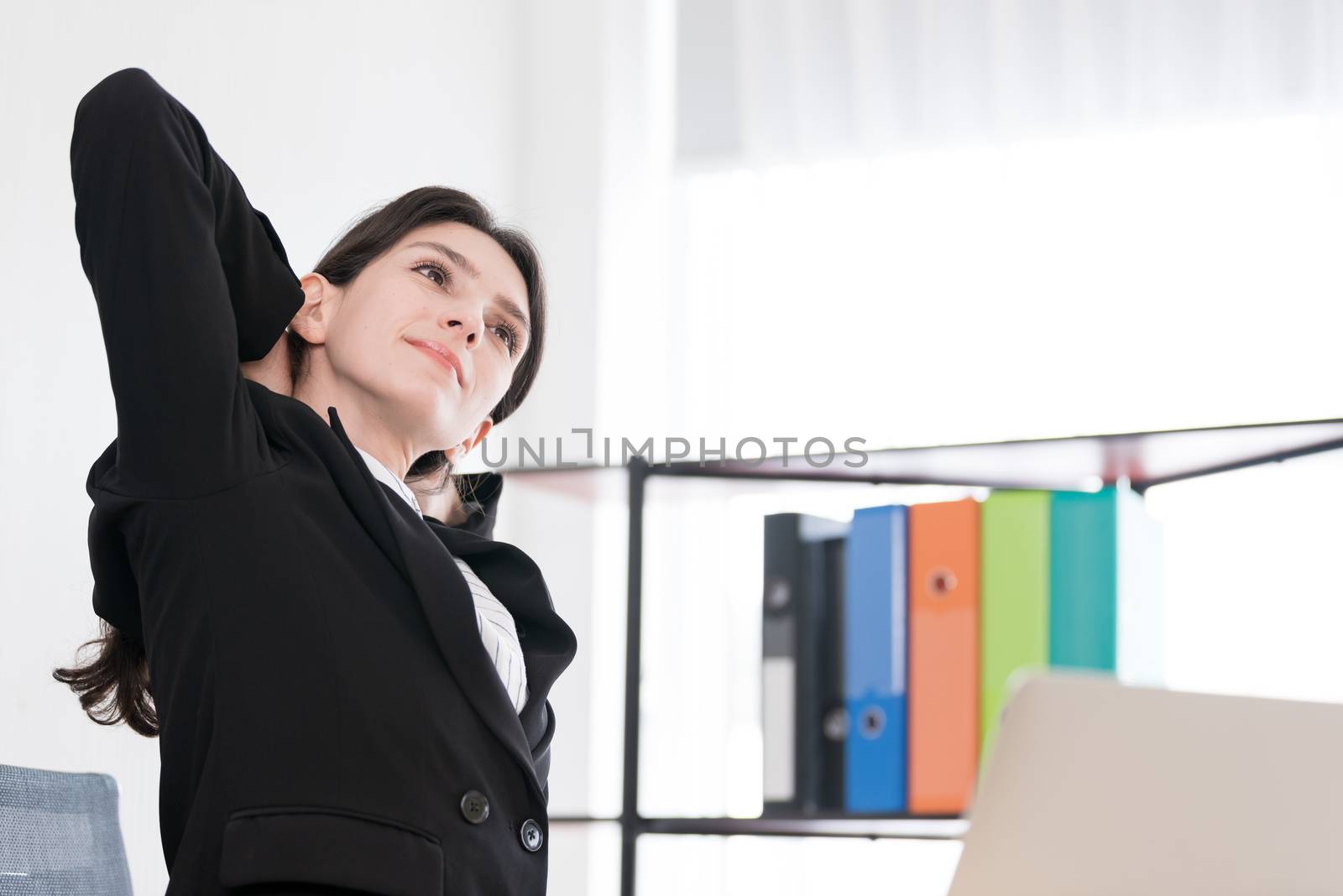 A businesswoman has taken a rest and stretching on the office chair with smiling and happiness.