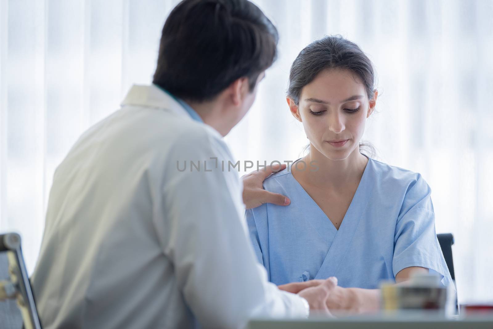 A doctor takes care of a sick patient woman with sadness and unhappiness at the hospital or medical clinic.