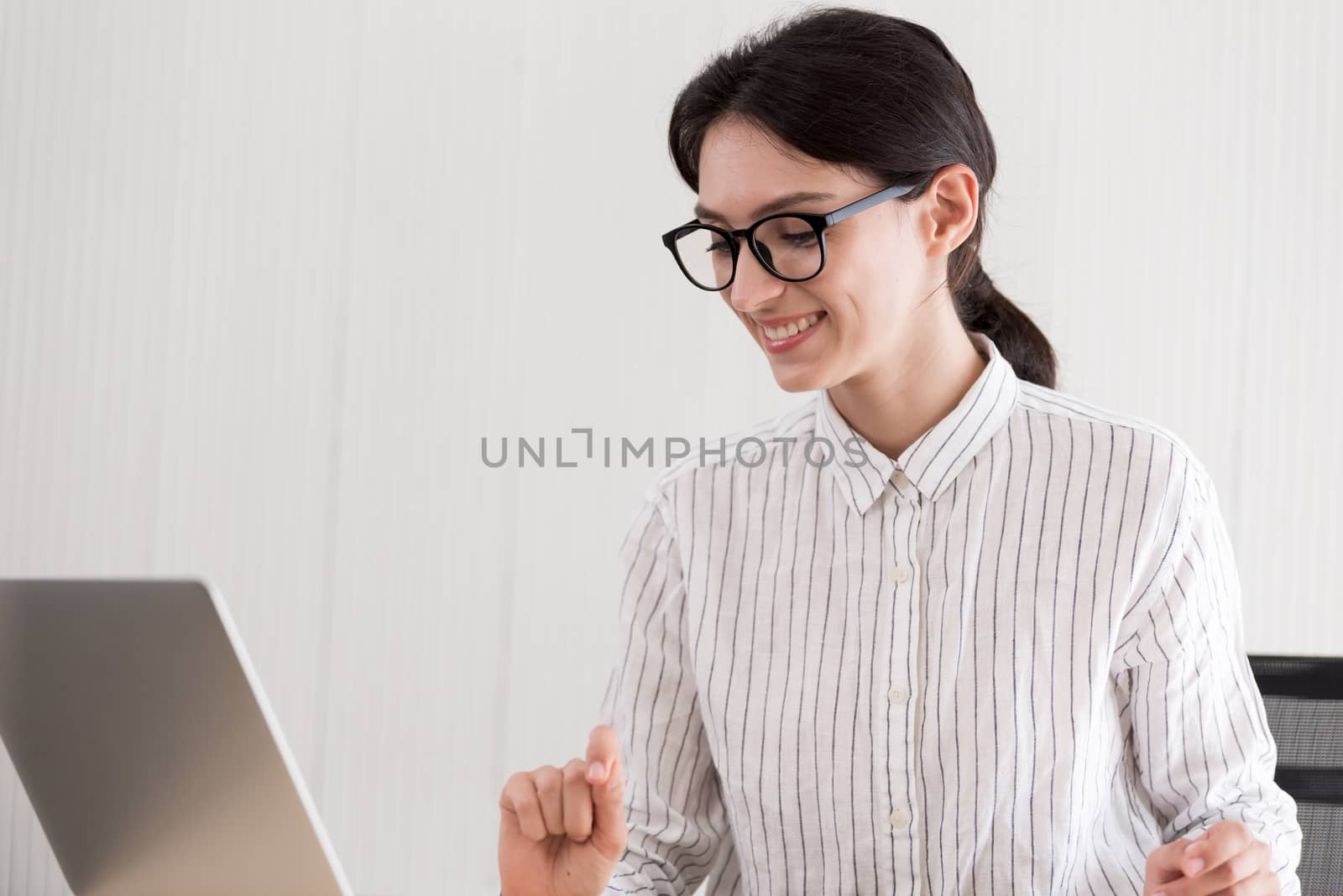 A businesswoman wearing glasses working with smiling and happiness at the office.