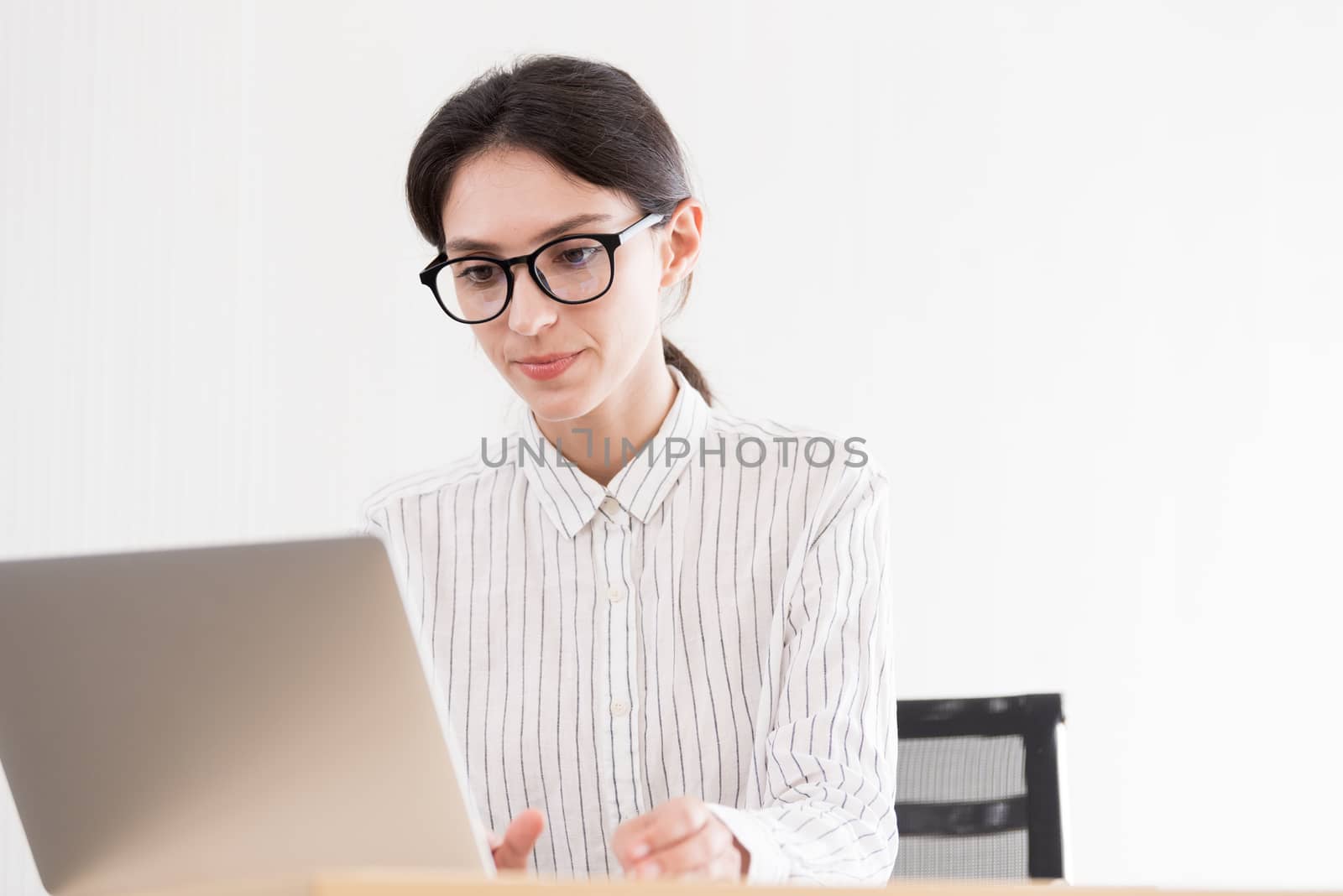 A businesswoman wearing glasses working with smiling and happine by animagesdesign