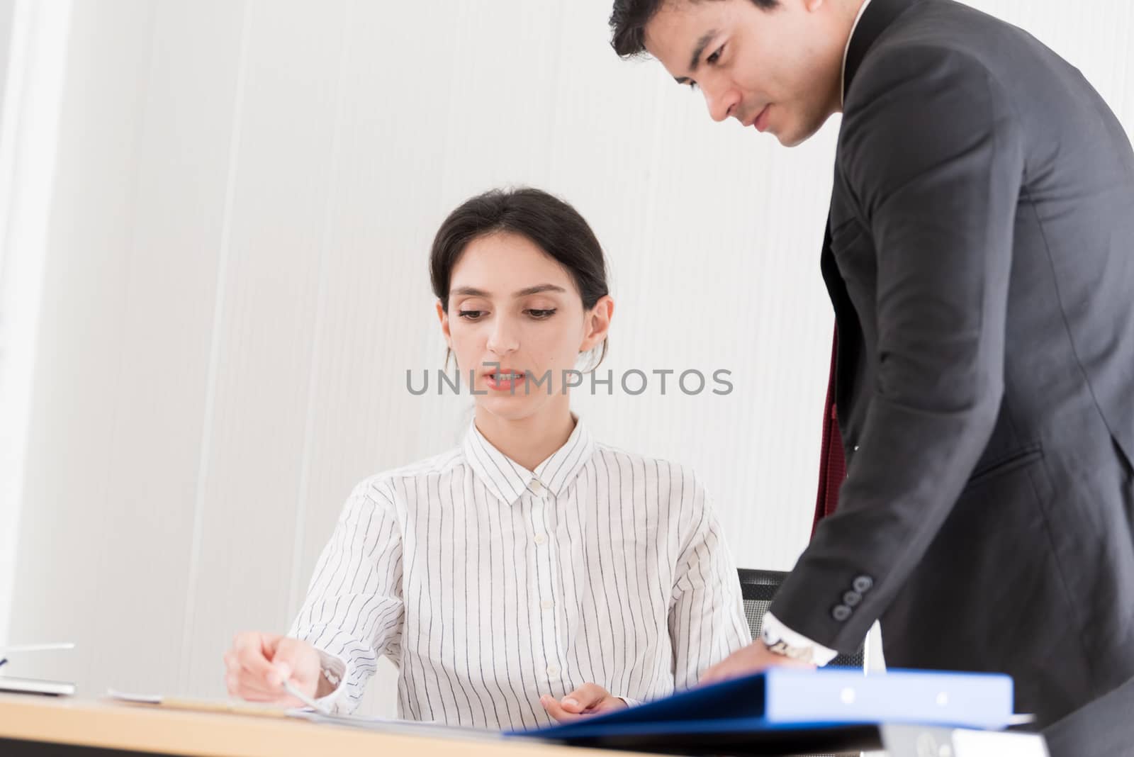 A manager and secretary working together in the office. by animagesdesign
