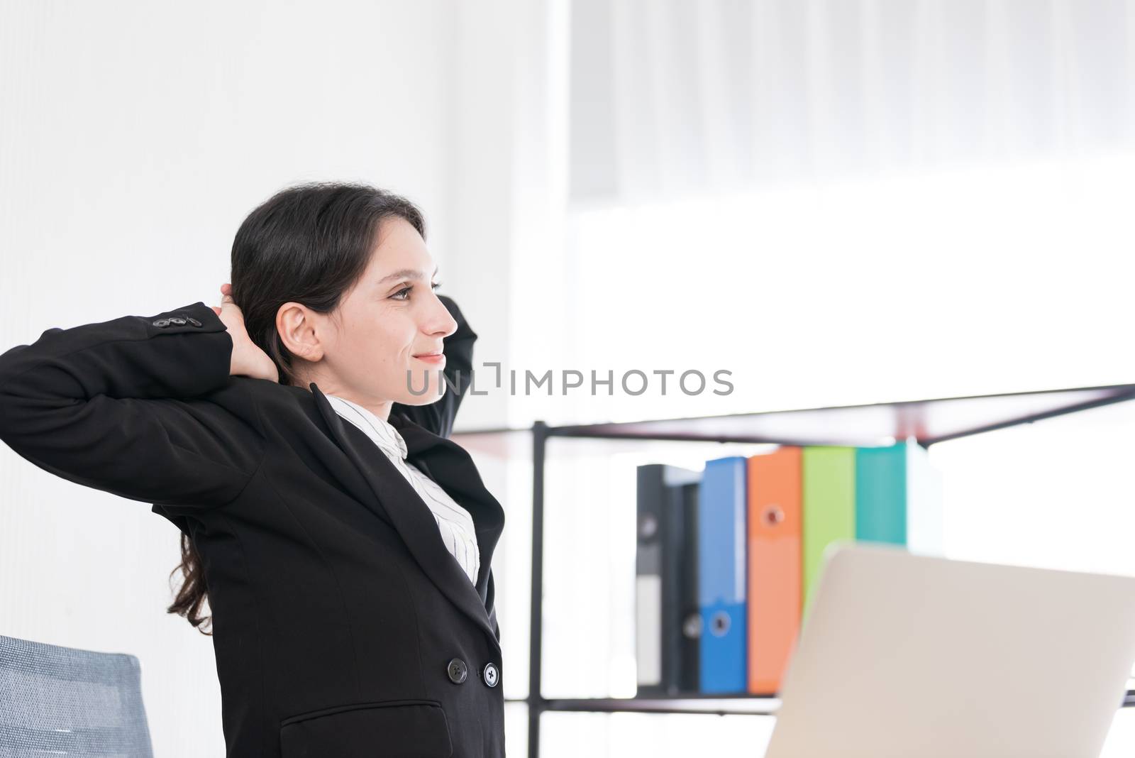 A businesswoman has taken a rest and stretching on the office ch by animagesdesign