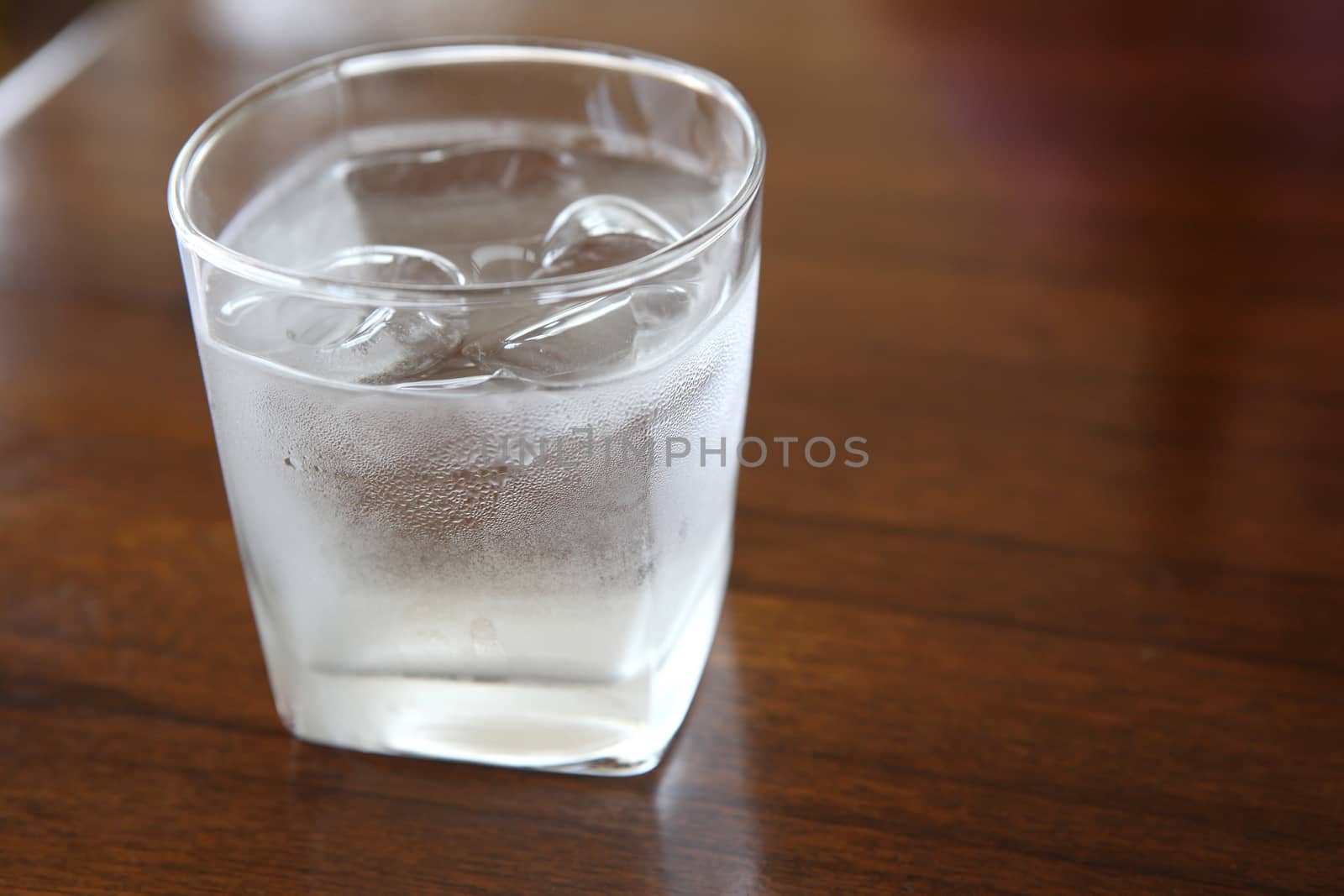 Glass with water on wood background by piyato