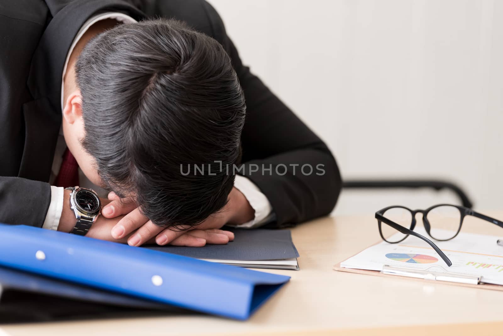 A businessman slept in the working time at the office.