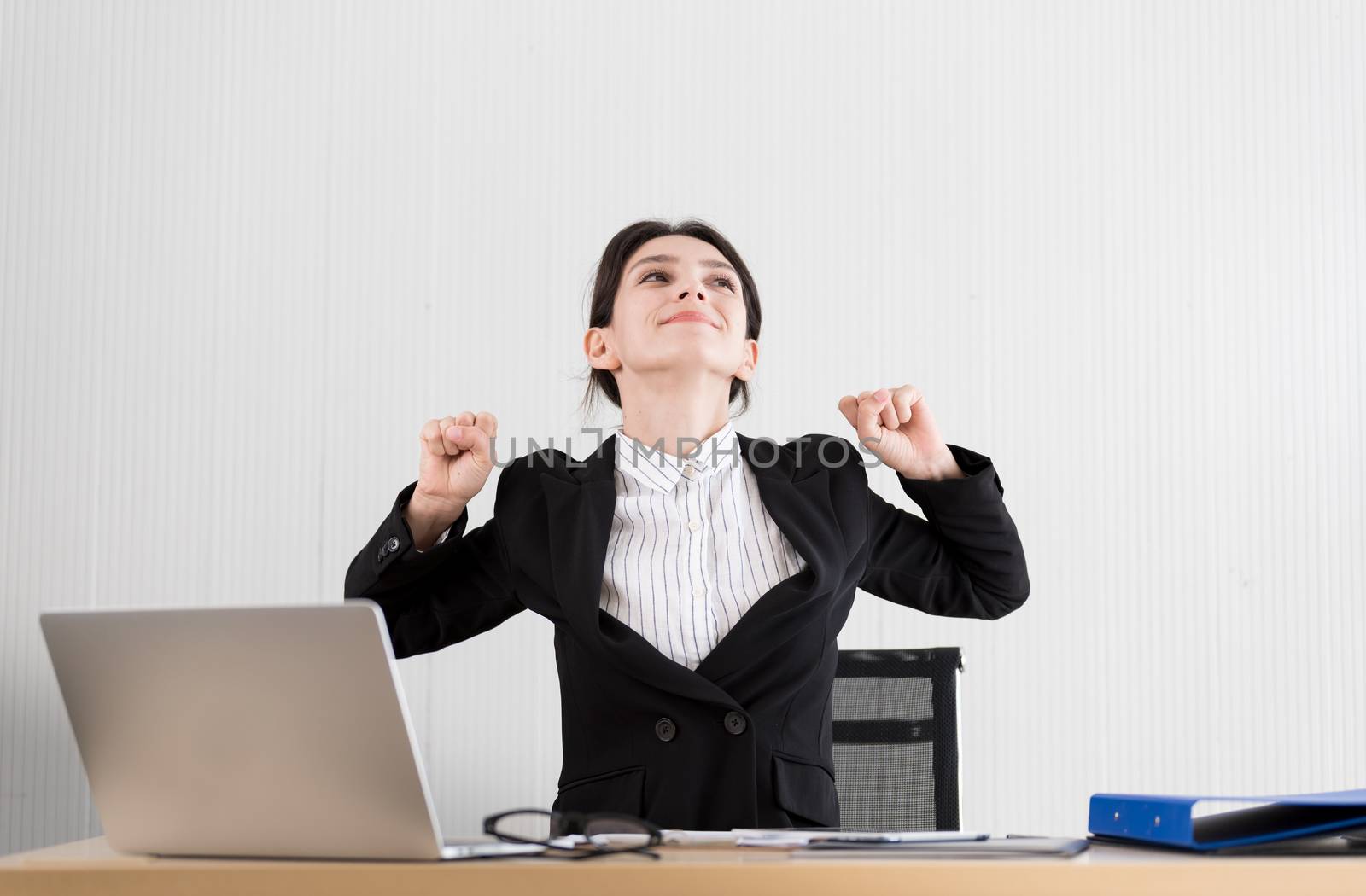 A businesswoman has taken a rest and stretching on the office chair with smiling and happiness.