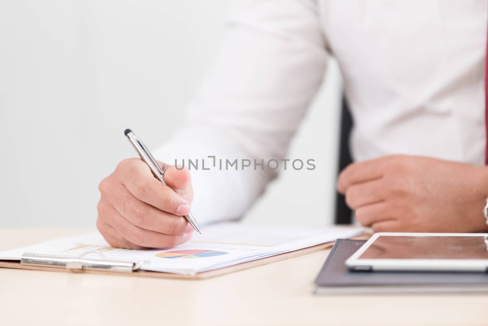 A businessman has writing the document report.