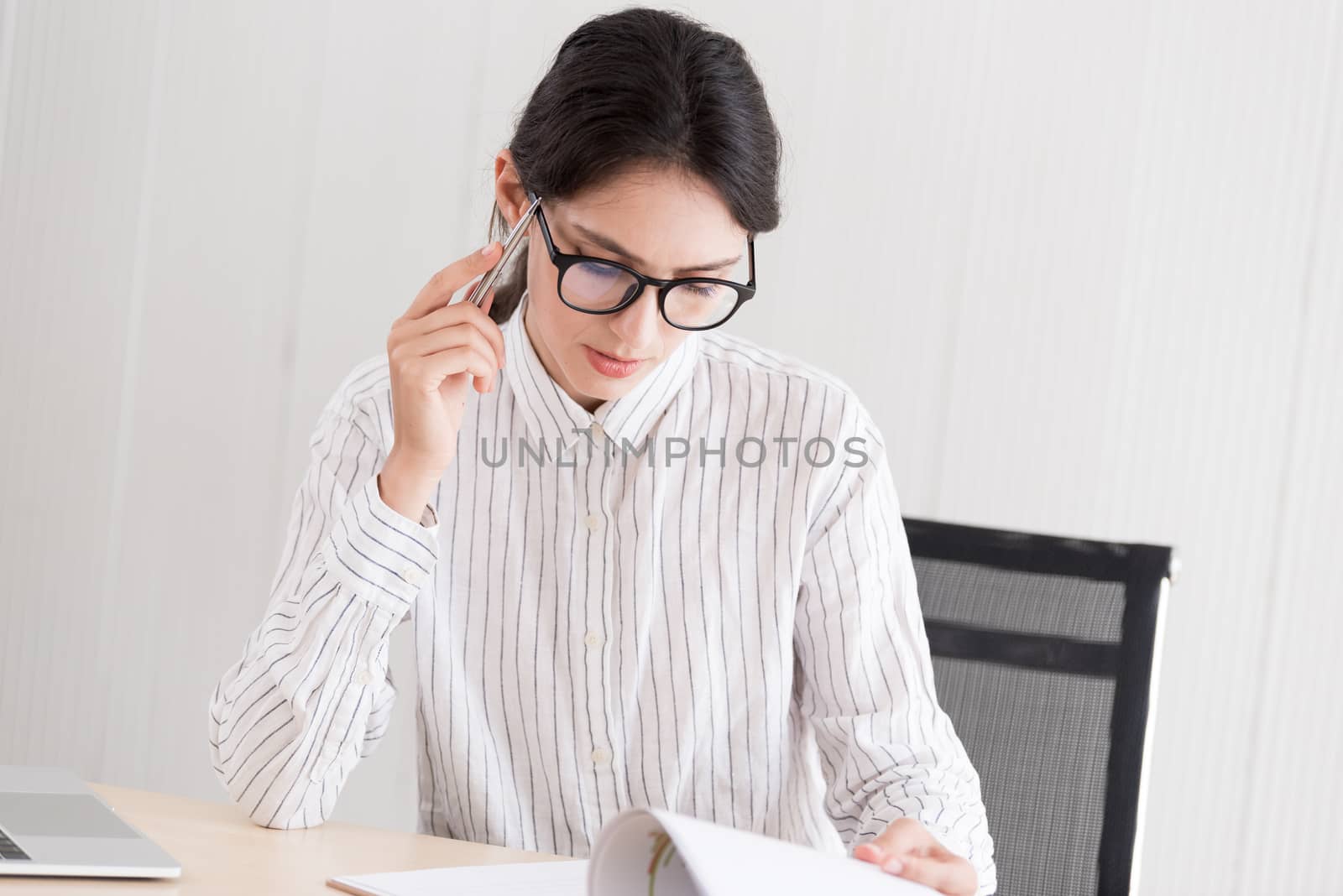 A businesswoman wearing glasses working with smiling and happiness at the office.