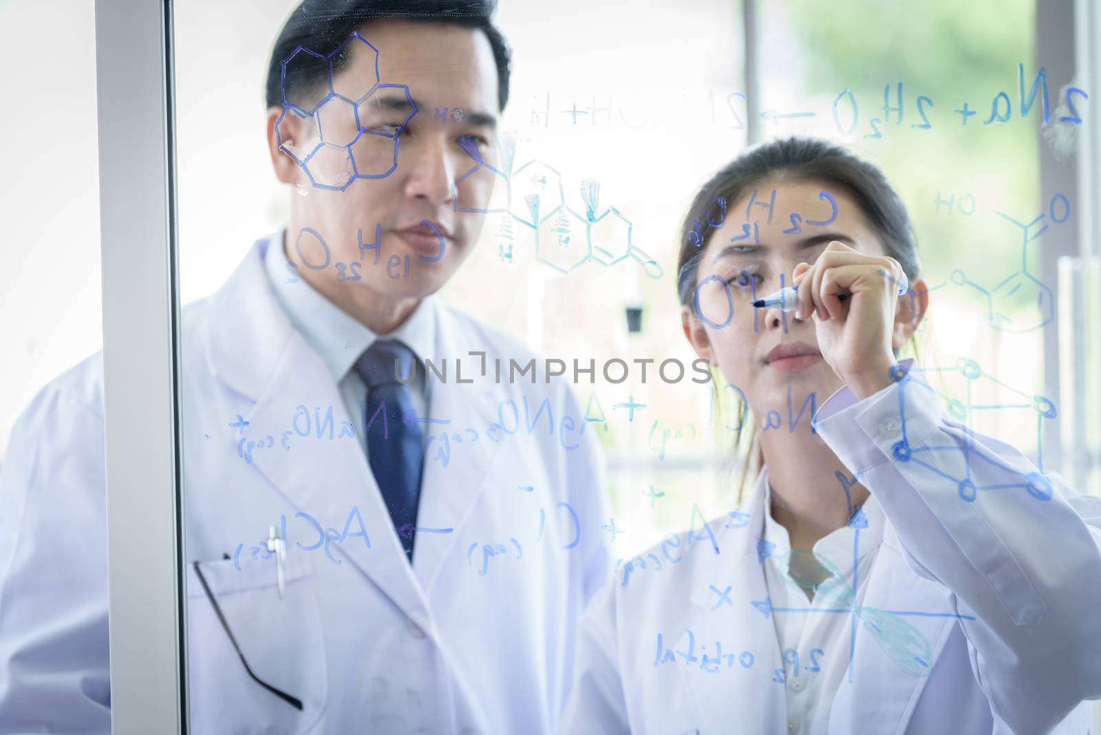 Asian scientist team has researching in laboratory. by animagesdesign