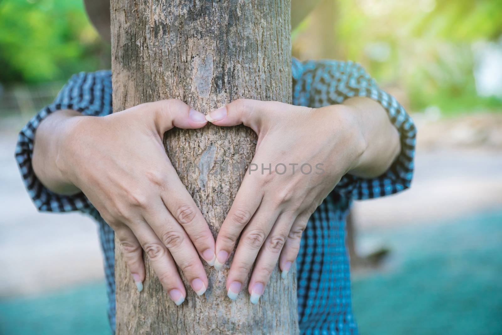 A rural woman made a heart-shaped hand to show love for the tree.